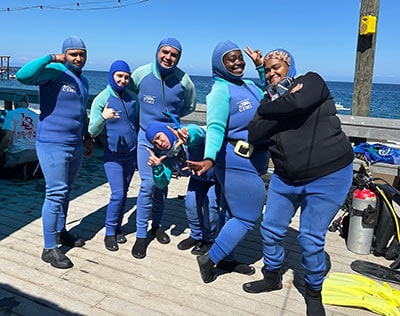 Divers in wetsuits ready for reef education activities at Reef Check.