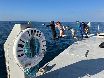 Dive team jumping into the ocean from a dock