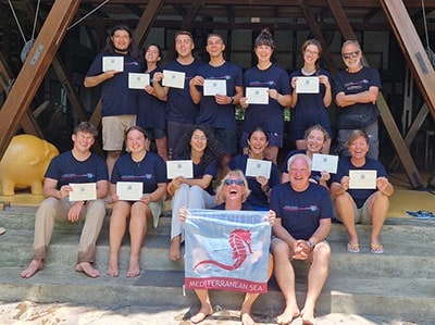 Group of Reef Check volunteers holding certificates after marine conservation training.