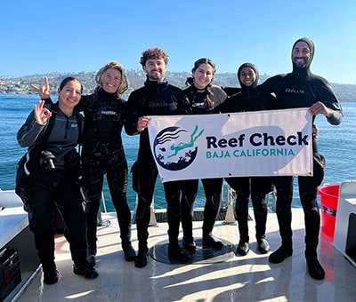 Reef conservation team with Reef Check Baja California banner on boat.